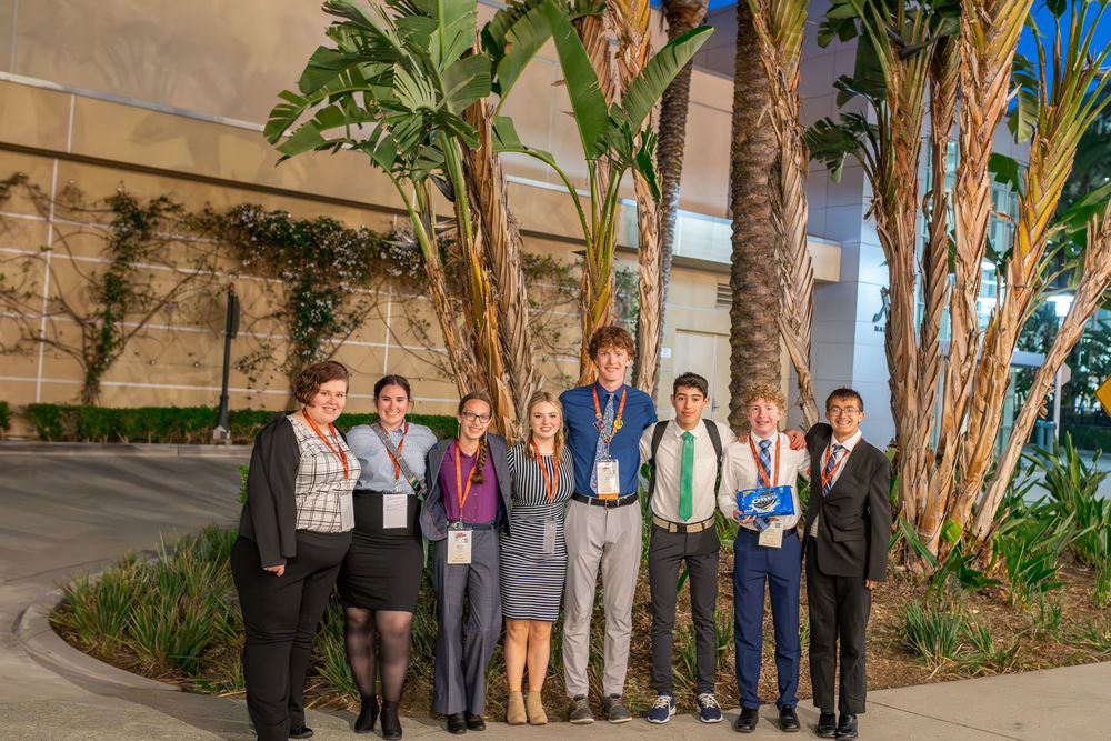 image of 8 students in front of palm trees